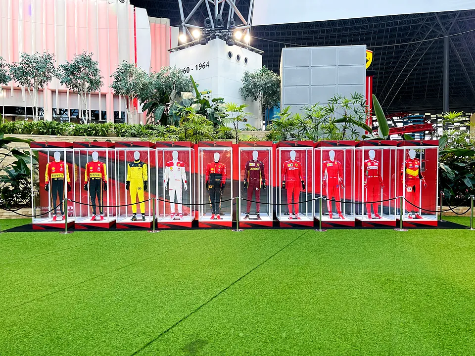 Display of racing suits in branded cases on artificial grass at Ferrari World Abu Dhabi