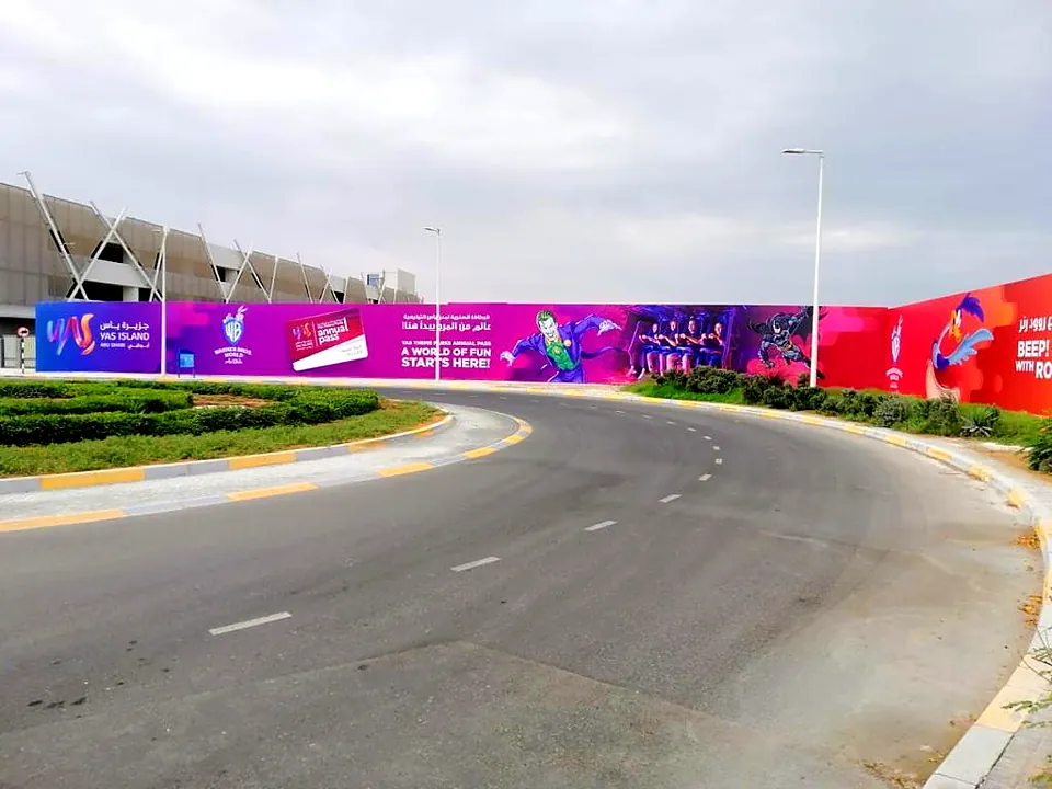 Curved roadside billboard hoarding promoting Yas Island theme parks in Abu Dhabi